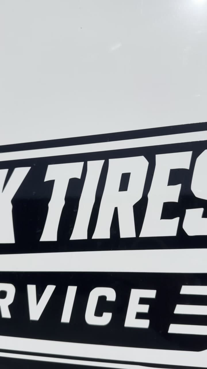 Cut vinyl lettering on the side of the white service van reading tires over service