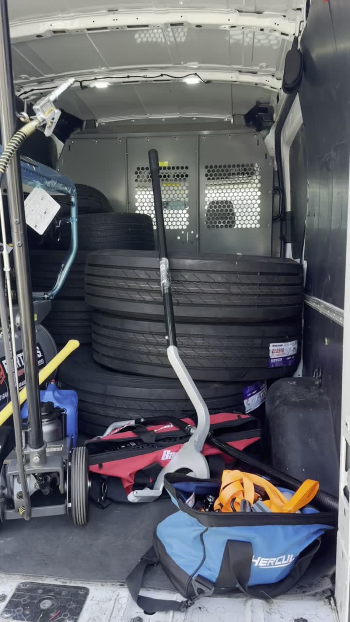 Inside the van: stacked tires, a jack, and tools